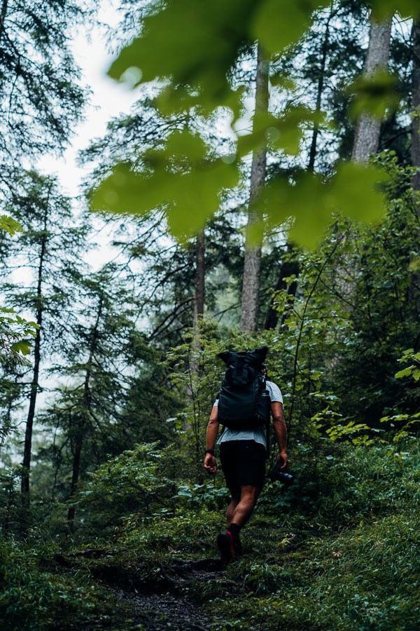 Ein Mann mit einem Rucksack, der durch einen Wald geht.