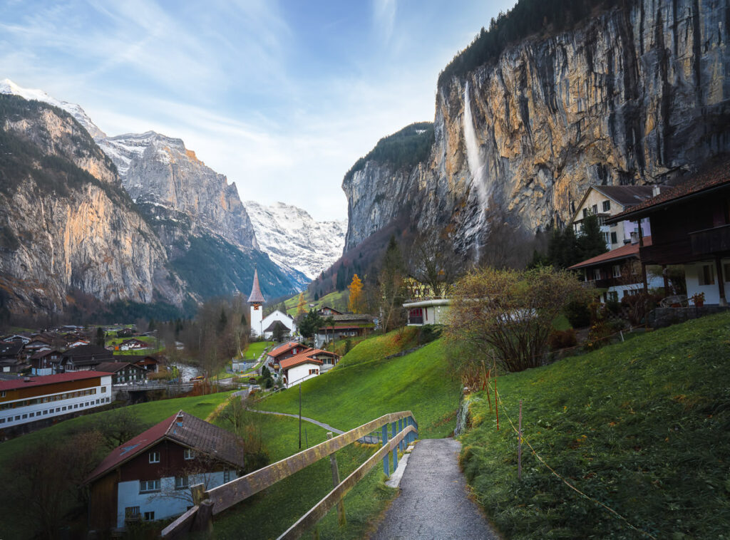 Ein Weg, der zu einem Dorf in der Schweiz führt.
