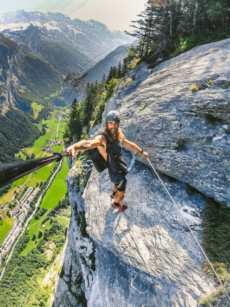 ein Mann an einem Seil auf einem Berggipfel.