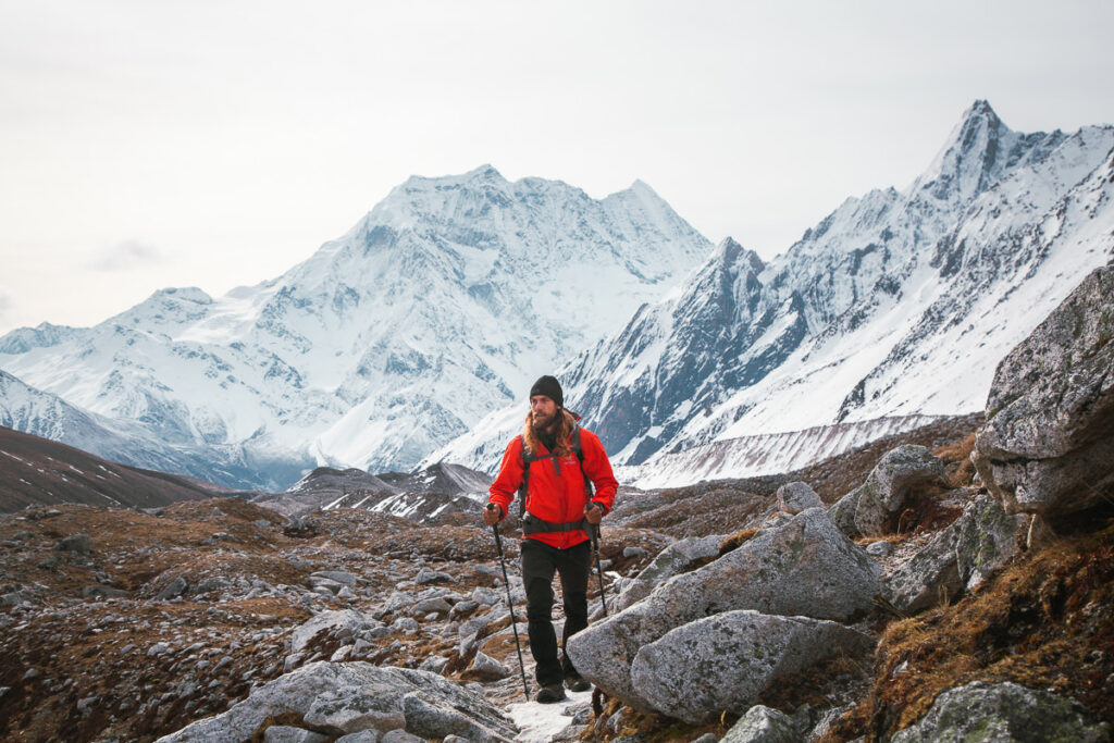 Ein Mann in einer roten Jacke wandert einen Berg hinauf